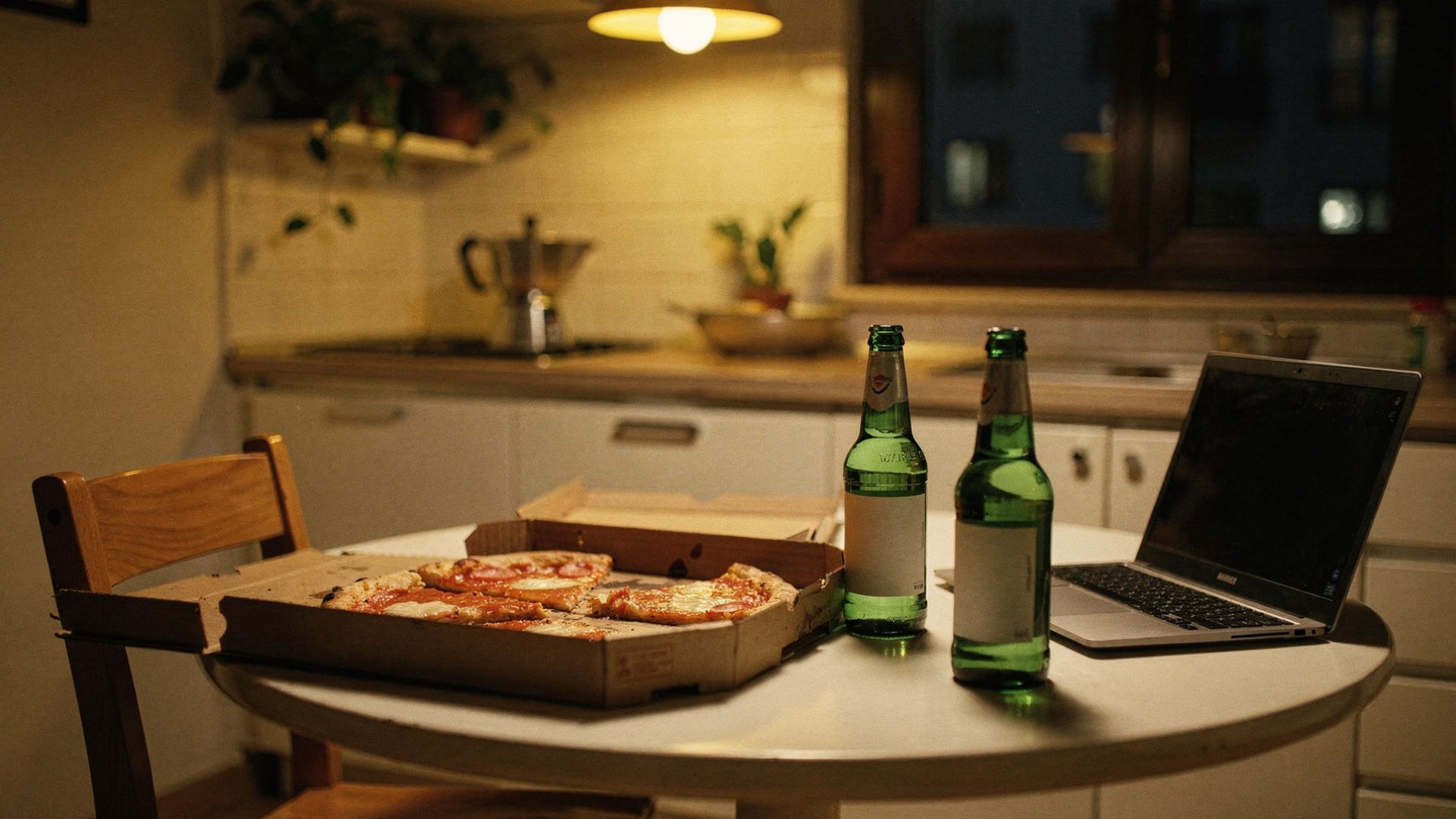 Tavolo cucina con due birre, pizza margherita e laptop, appartamento studenti via Padova Milano